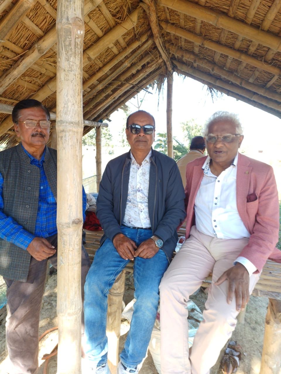 Guests relaxing in the bamboo-and-thatch viewing hut by the pond